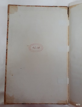 Oval stamp in red ink with handwritten red ink characters