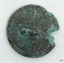 Metal disc, rough, irregular circle, raised area in centre of back containing small hole.