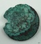Metal disc, rough, irregular circle.