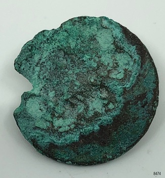 Metal disc, rough, irregular circle.