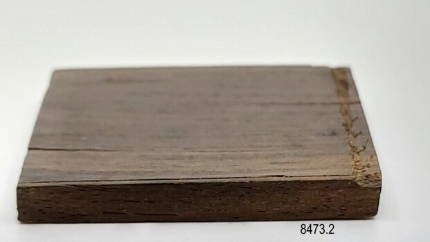 One of four equal sized sides of a square of brown wood.