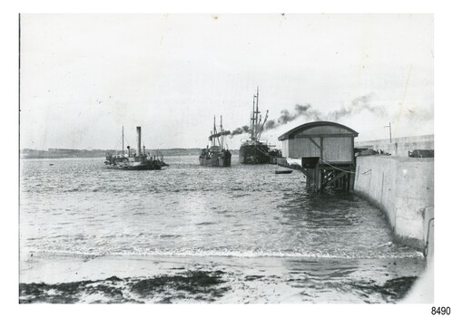 Black and white photograph of Lady Bay with vessels, lifeboat shed and rocket house, Breakwater