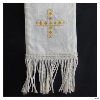 Close-up of one end; ribbon and embroidery form a cross. Edge is fringed i white.
