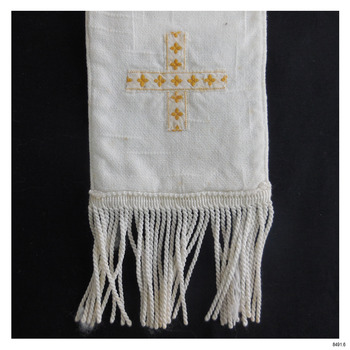 Close-up of one end; ribbon and embroidery form a cross. Edge is fringed i white.
