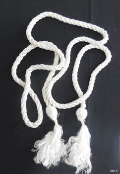 Soft white cord, twisted and knotted, with tassel at both ends