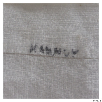Black pen inscription written onto hem of cloth