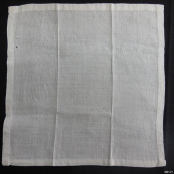 Square of white linen with hand stitched hem