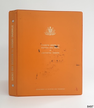 Orange hard covered book with gold embossed test and Coat of Arms on the cover 