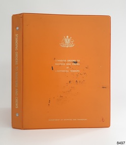 Orange hard covered book with gold embossed test and Coat of Arms on the cover 