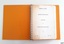 Metal binding holds many cream coloured pages that have rounded outer corners and printed text