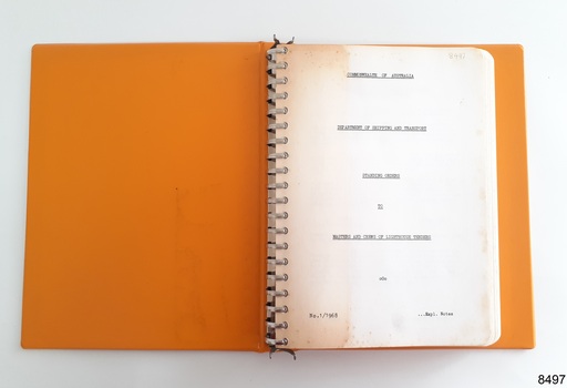 Metal binding holds many cream coloured pages that have rounded outer corners and printed text