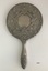 Back view of ornate hand mirror.