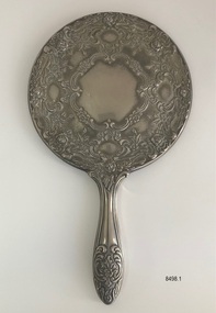 Back view of ornate hand mirror.