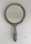 Front view of ornate hand mirror.