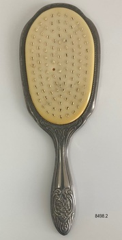 Front view of ornate hair brush with no bristles.