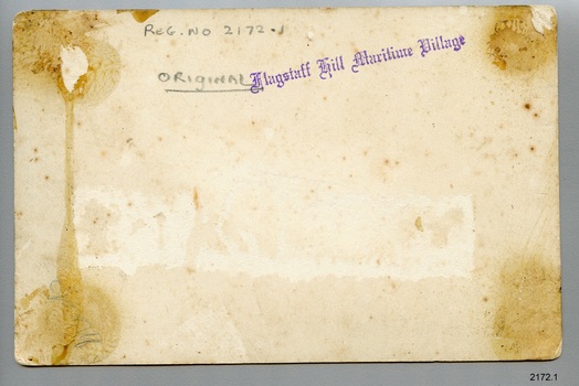 Rectangular photograph has inscriptions, stamp and remnants of mounting and label