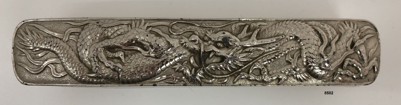 Top view of clothes brush showing ornate dragon design.