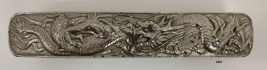 Top view of clothes brush showing ornate dragon design.