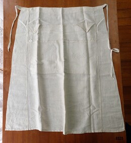 Linen apron with labelled pockets and waist ties.