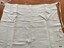 Linen apron with labelled pockets and waist ties.