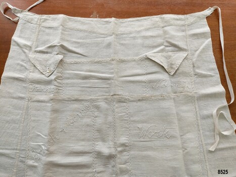 Linen apron with labelled pockets and waist ties.