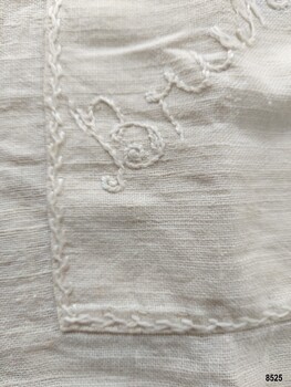 Feather stitch and stem stitch embroidery on apron pocket.