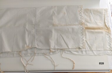 A cotton bolster sham with drawstrings and lace edging.