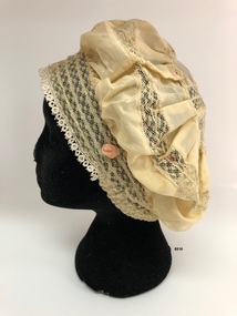 Side view of pale yellow silk boudior cap.