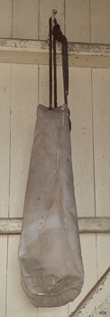Beige long canvas bag with round base and drawerstring closure