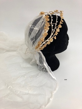 Side view of wax flower bridal headpiece with top of veil coming from it.