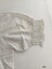 View of crocheted lace and embroidery detail on sleeve