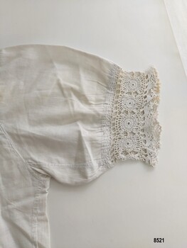 View of crocheted lace and embroidery detail on sleeve