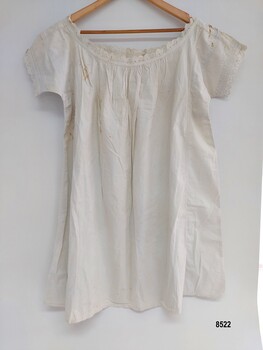 Back view of white, cotton chemise with pintucks and broderie anglaise on sleeves and neckline