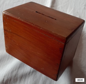 rectangular wooden money box with felt pad on base