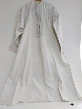 A long, white, lady's cotton nightgown decorated with pintucks and broderie anglaise