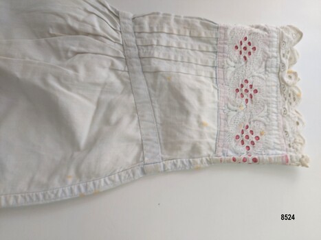 The end of the long sleeve is gathered into a V shaped cuff decorated with pintucks and broderie anglaise 