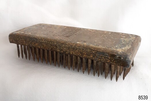 Rectangular metal made of layers, above rows of metal spikes