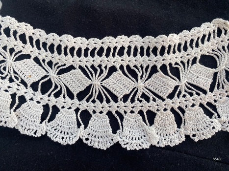 Close view of section of crochet lace to show repeat pattern.