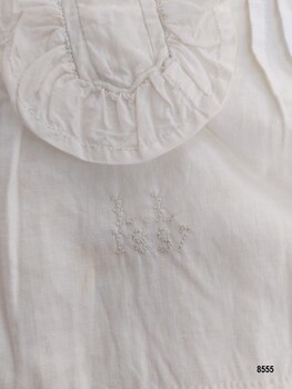 Cross stitched initials and date below opening frill
