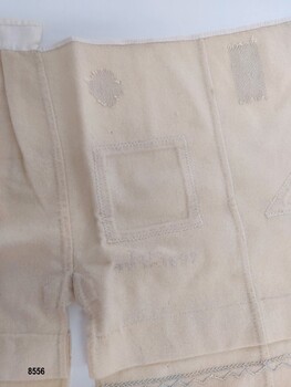 Cream flannel sampler with darned patches, inserted patches and handstitched gusset, seams and binding