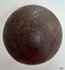 Round black ball with shiny surface damaged by pitting