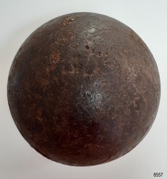 Round black ball with shiny surface damaged by pitting