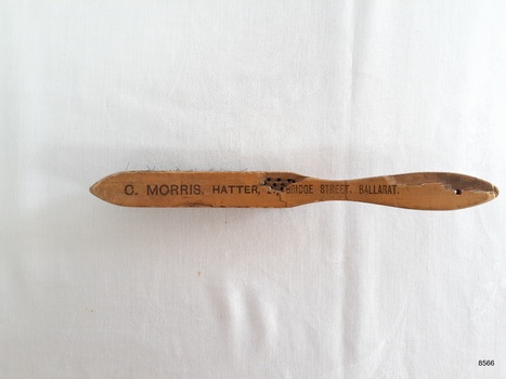 Top view of hat brush showing inscription of supplier.