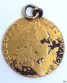 Gold coin with inscriptions and portrait. Loop is inserted into top, and a ring is threaded through it