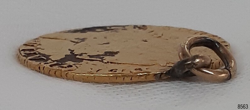 Worn edges and surface, deep groove in buckled ring, loop is bent at and angle