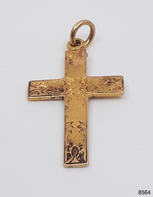 Gold cross has loop and ring, and hand engraved front