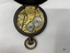 Inside view of fob watch showing workings and inscriptions.