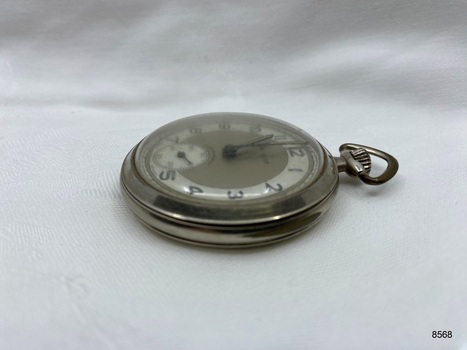 Side view of silver coloured fob watch.