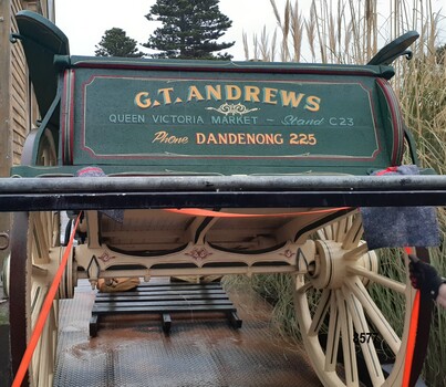 Back of dray painted green and decorated with sign writing advertising "G. T. Andrews" plus detail of bottom of dray and wooden wheels.