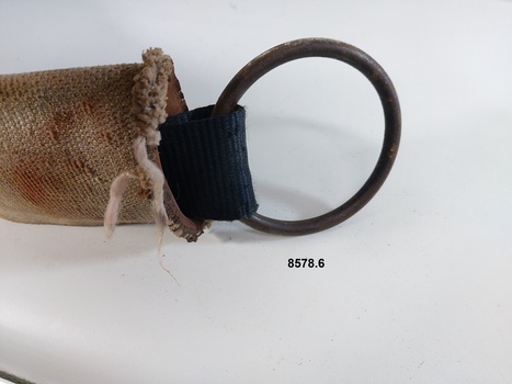 Close up view of the webbing covering the leather strap and the metal ring